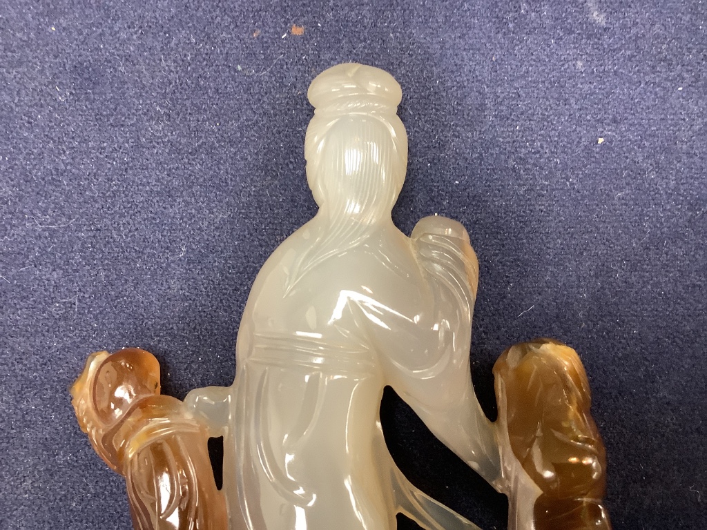 An early 20th century Chinese agate group of Guanyin and two boys, wood stand